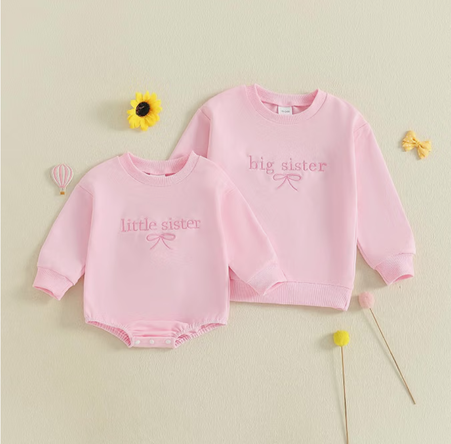 Matching pink big sister and little sister shirts with embroidered text and a bow